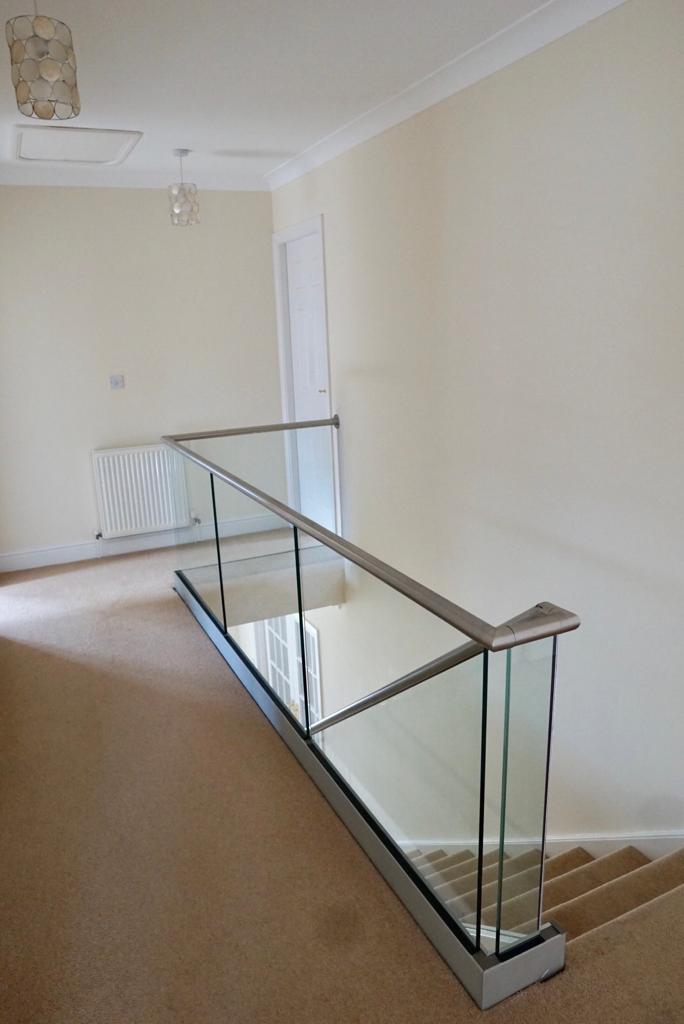 New glass balustrade with a bottom glazing channel and a stainless steel slotted handrail example 3