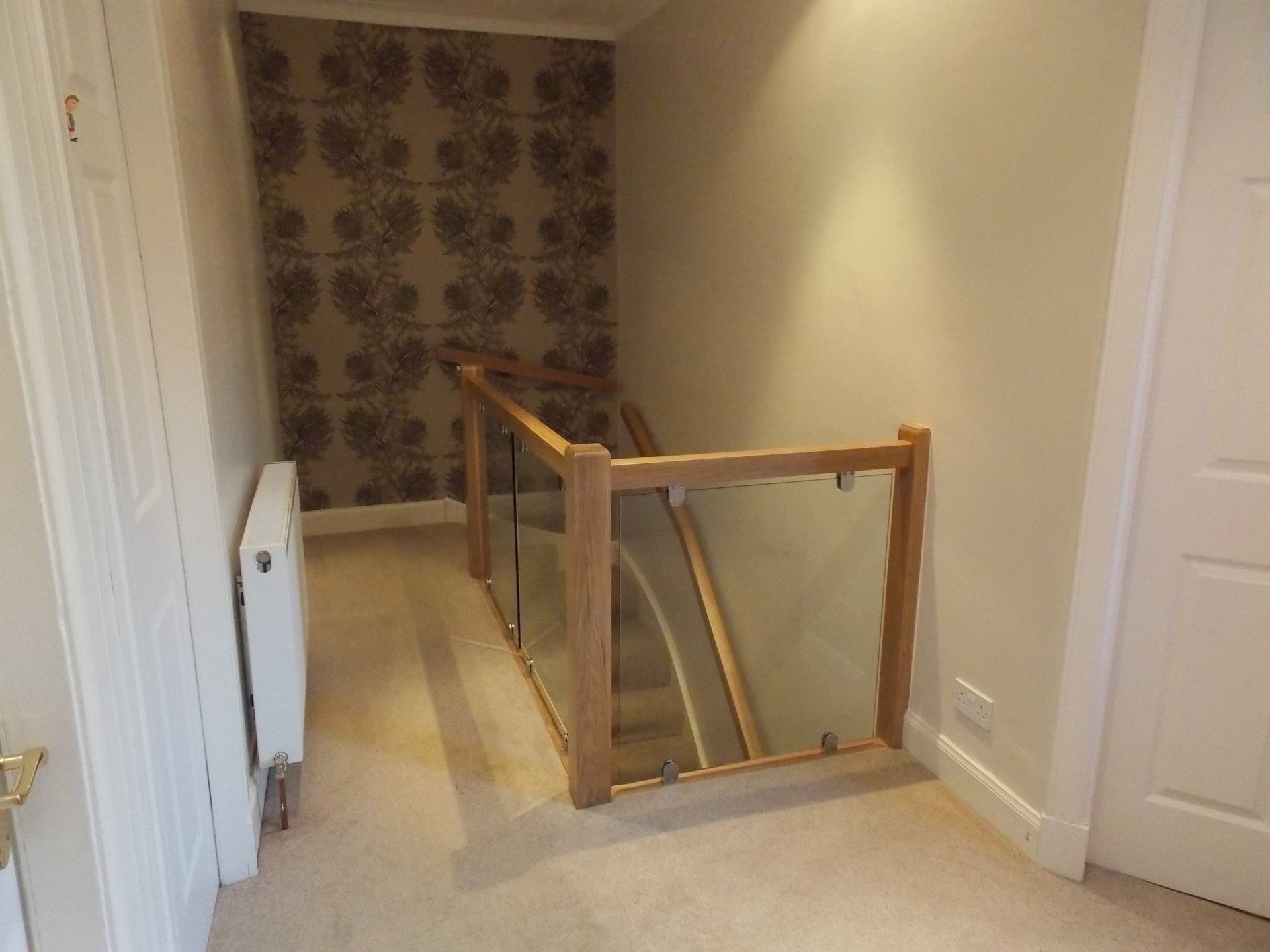Oak and glass balustrade and oak handrail mounted on chrome brackets example 1