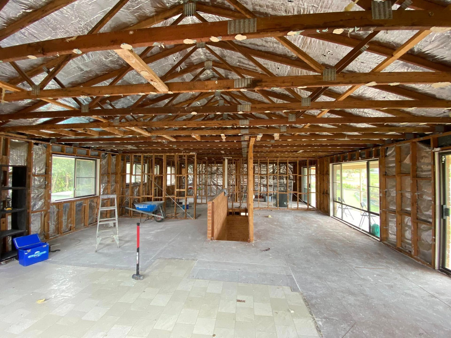 Interior of a house undergoing renovation, showing exposed framing, roof beams, and insulation. — Barrington Coast Homes in Old Bar, NSW