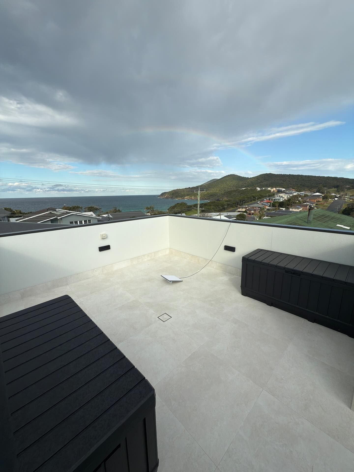 Modern white two-story house with a car in the garage, gray driveway, and blue sky. — Barrington Coast Homes in Tallwoods, NSW