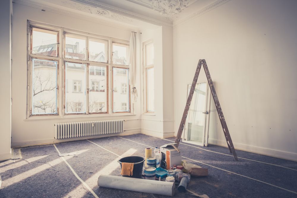 An Empty Room With A Large Window And Painting Supplies On The Floor — Barrington Coast Homes in Old Bar, NSW
