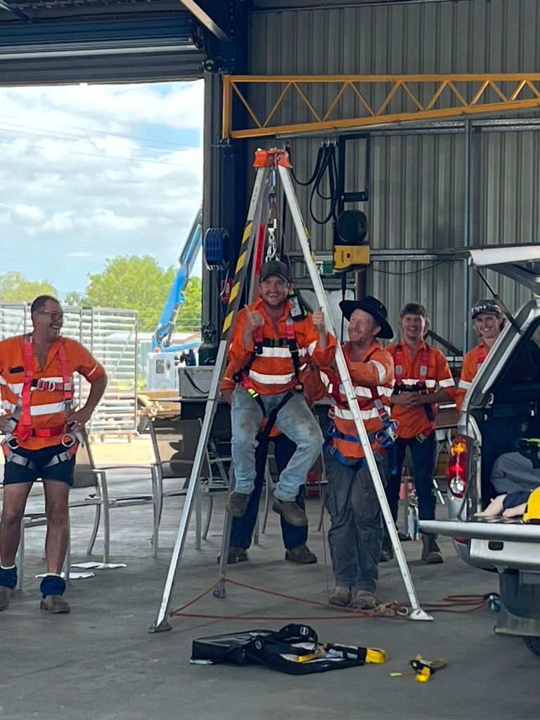 A group of men are standing around a tripod in a garage.