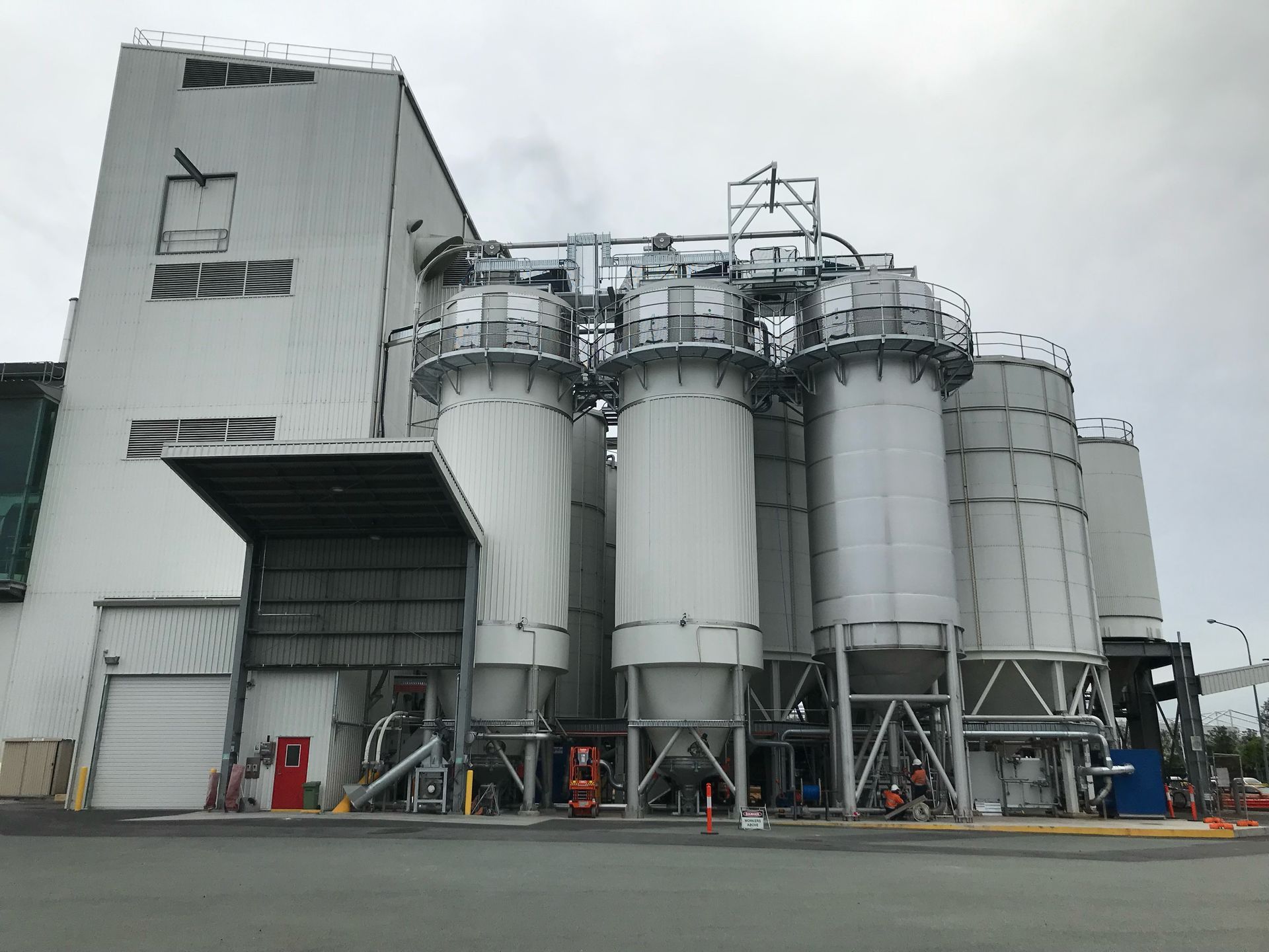 A large white building with a lot of silos in front of it.