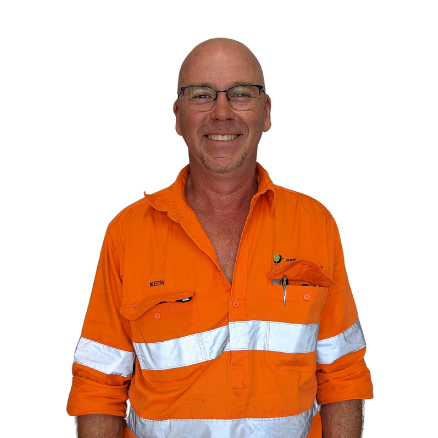 A man wearing glasses and an orange shirt is smiling