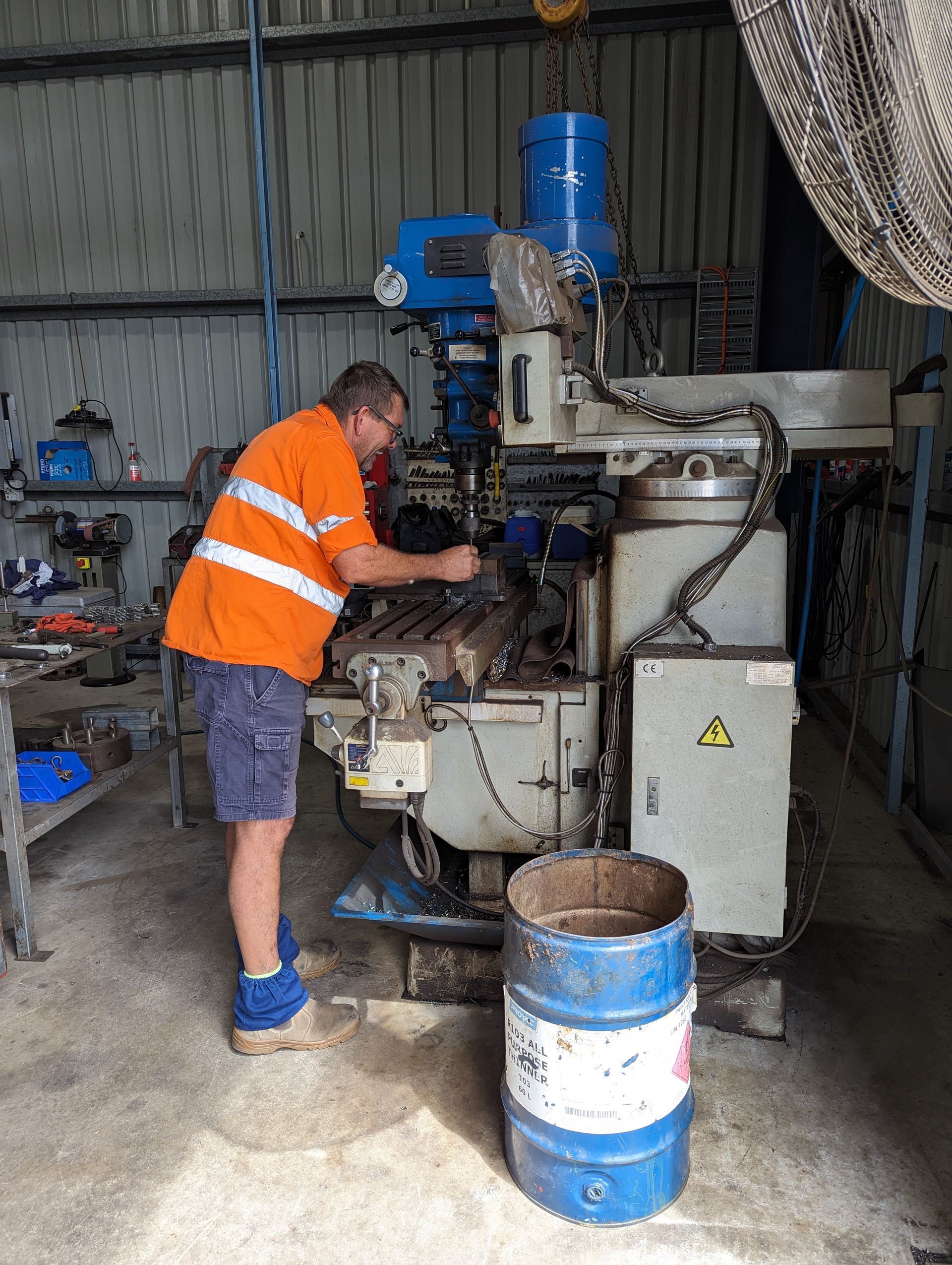 A man is working on a machine in a garage.