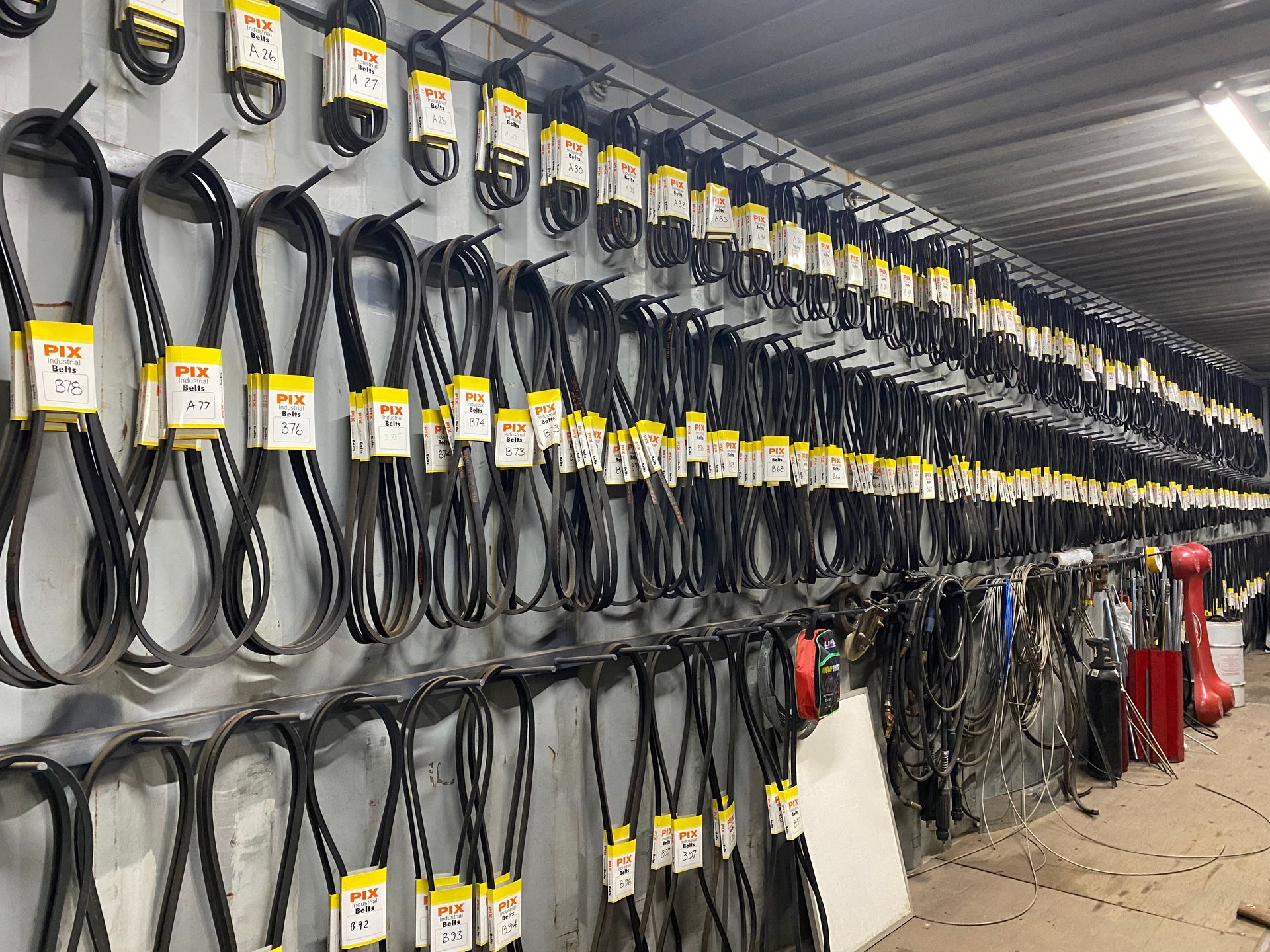 A warehouse filled with lots of belts hanging on the wall.