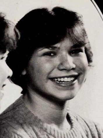 A woman is smiling in a black and white photo.