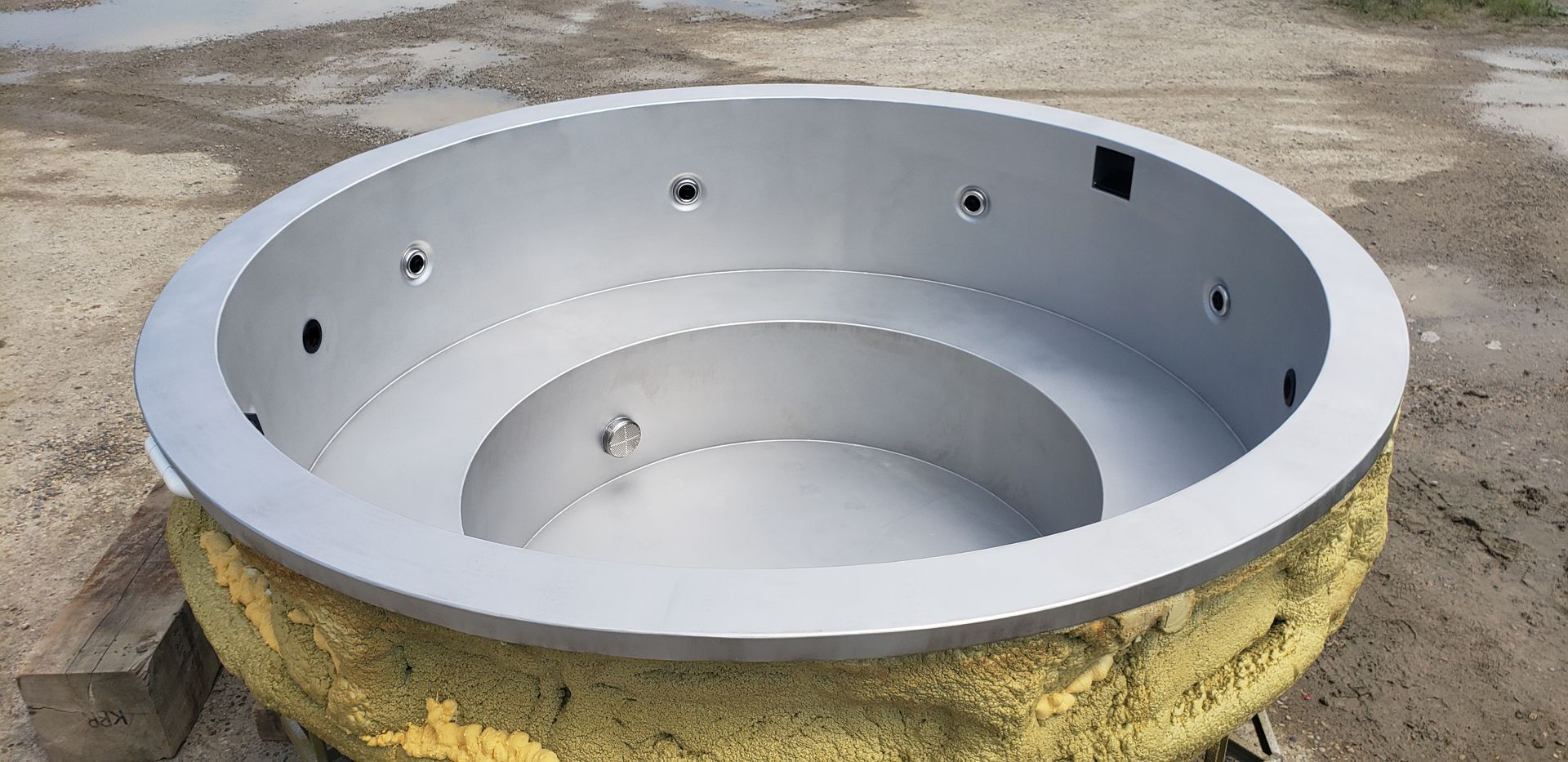 Circular, stainless steel hot tub shell with insulation.