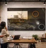 Three people viewing a large wall art display in a modern office meeting room
