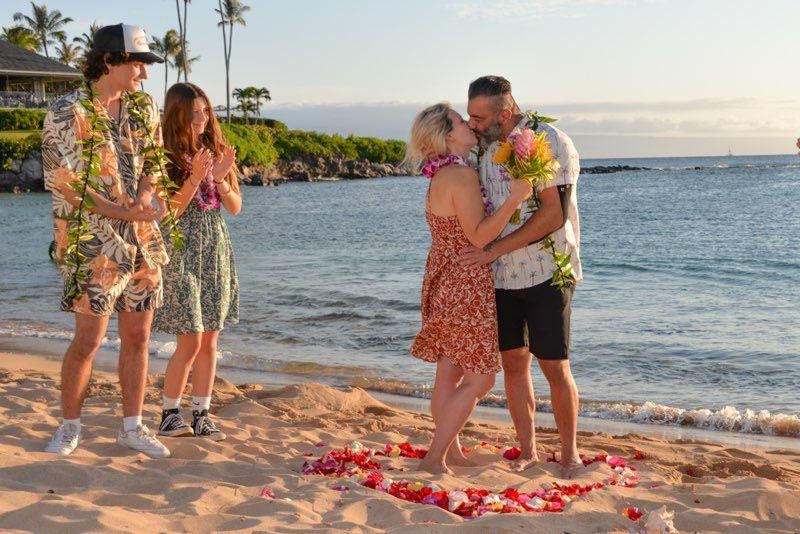 people on beach with flower petals in sand