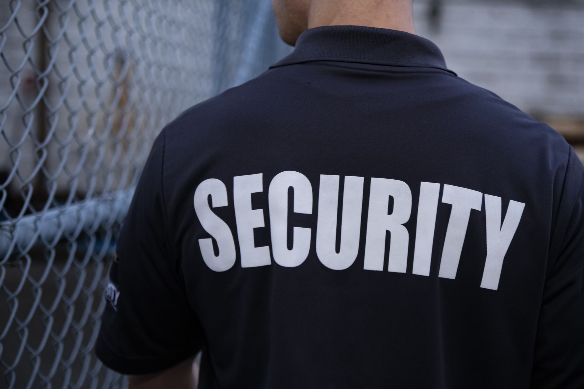 Back of a security guard's navy polo shirt with 