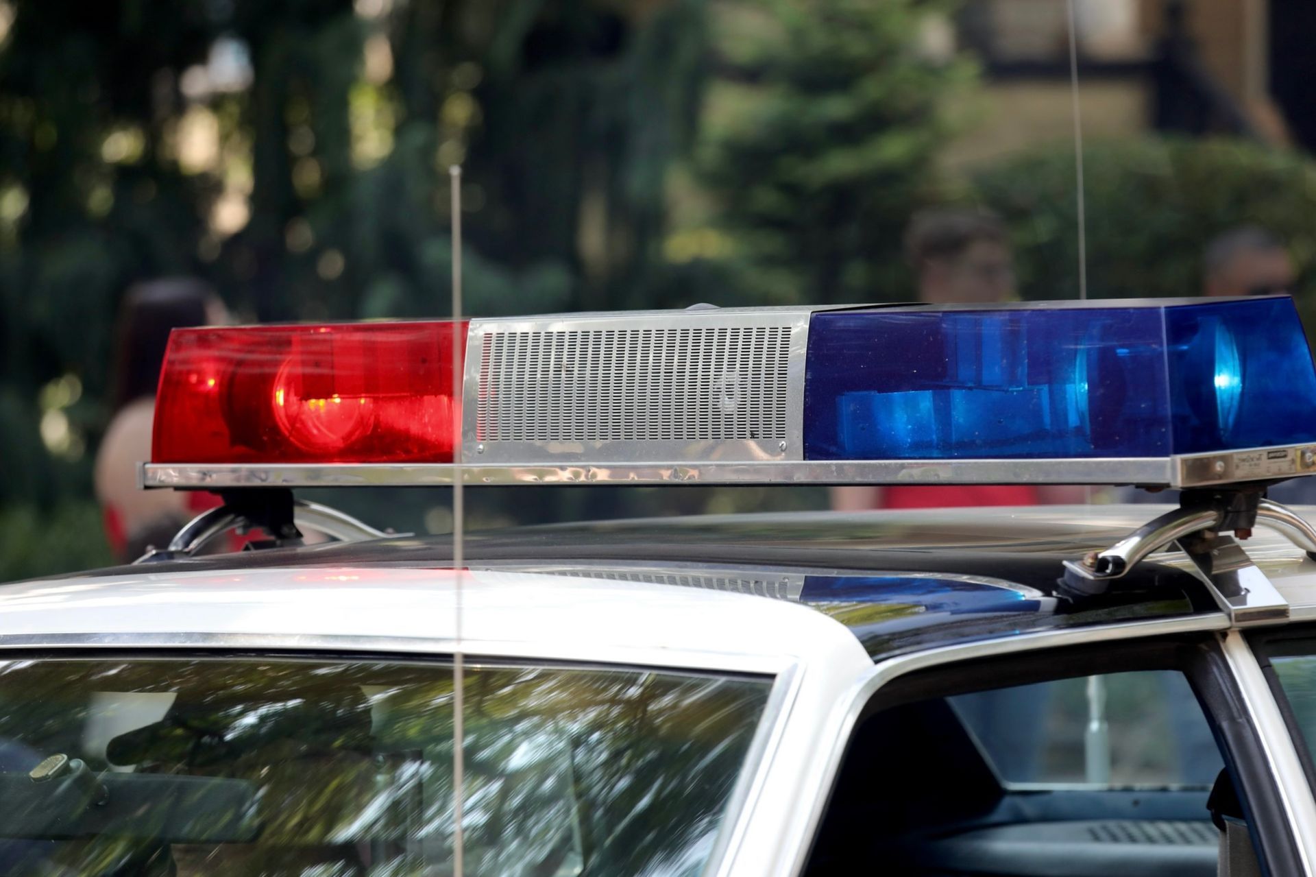 Police car with flashing red and blue lights.
