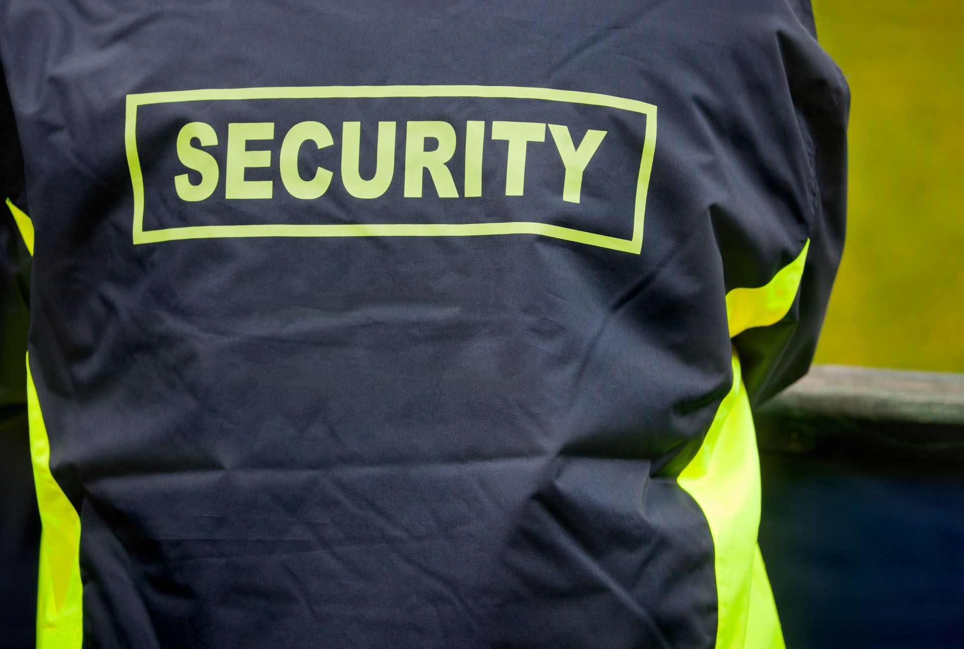 Back of a security guard's dark jacket with a
