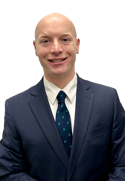 Man in navy suit, white shirt, green tie, smiling, against white background.