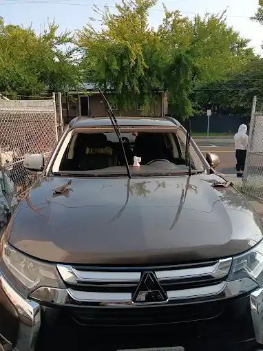 A mitsubishi outlander is parked on the side of the road.