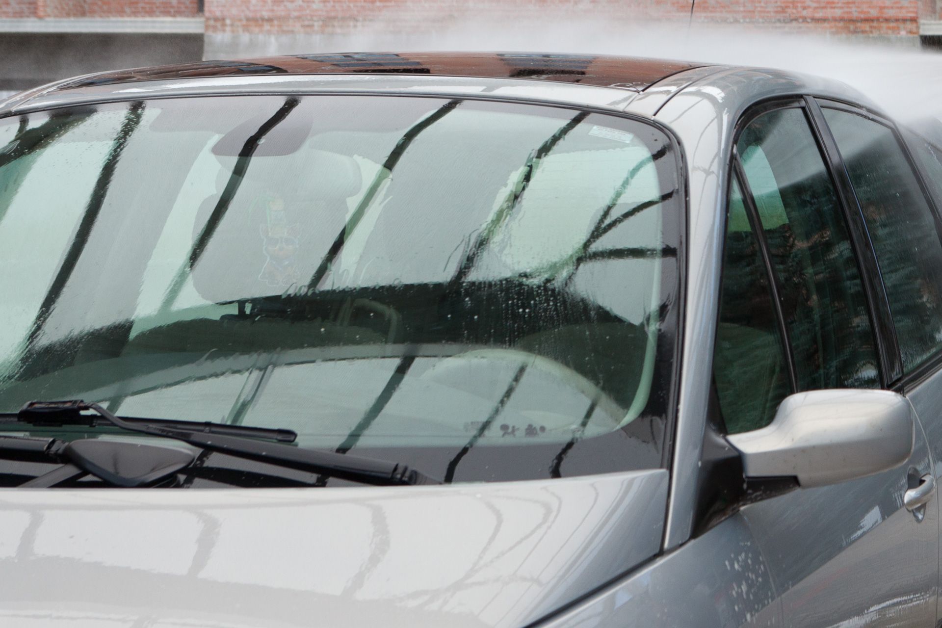 A close up of a car 's windshield and hood.