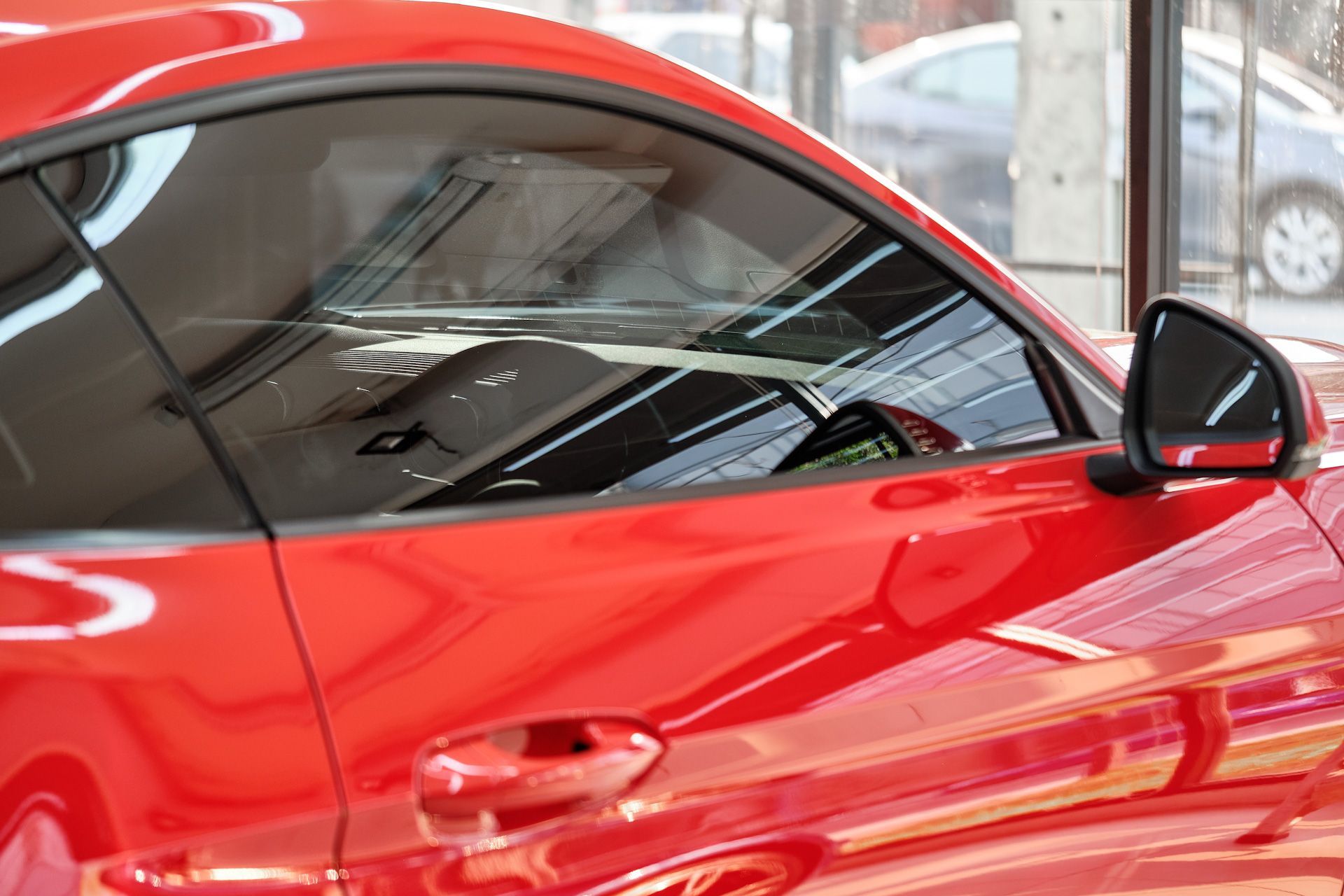 A red sports car is parked in a showroom.