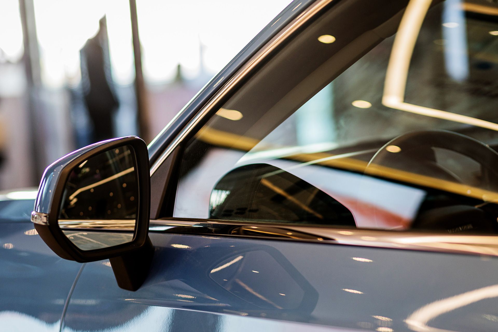 A close up of a car 's side mirror in a showroom.