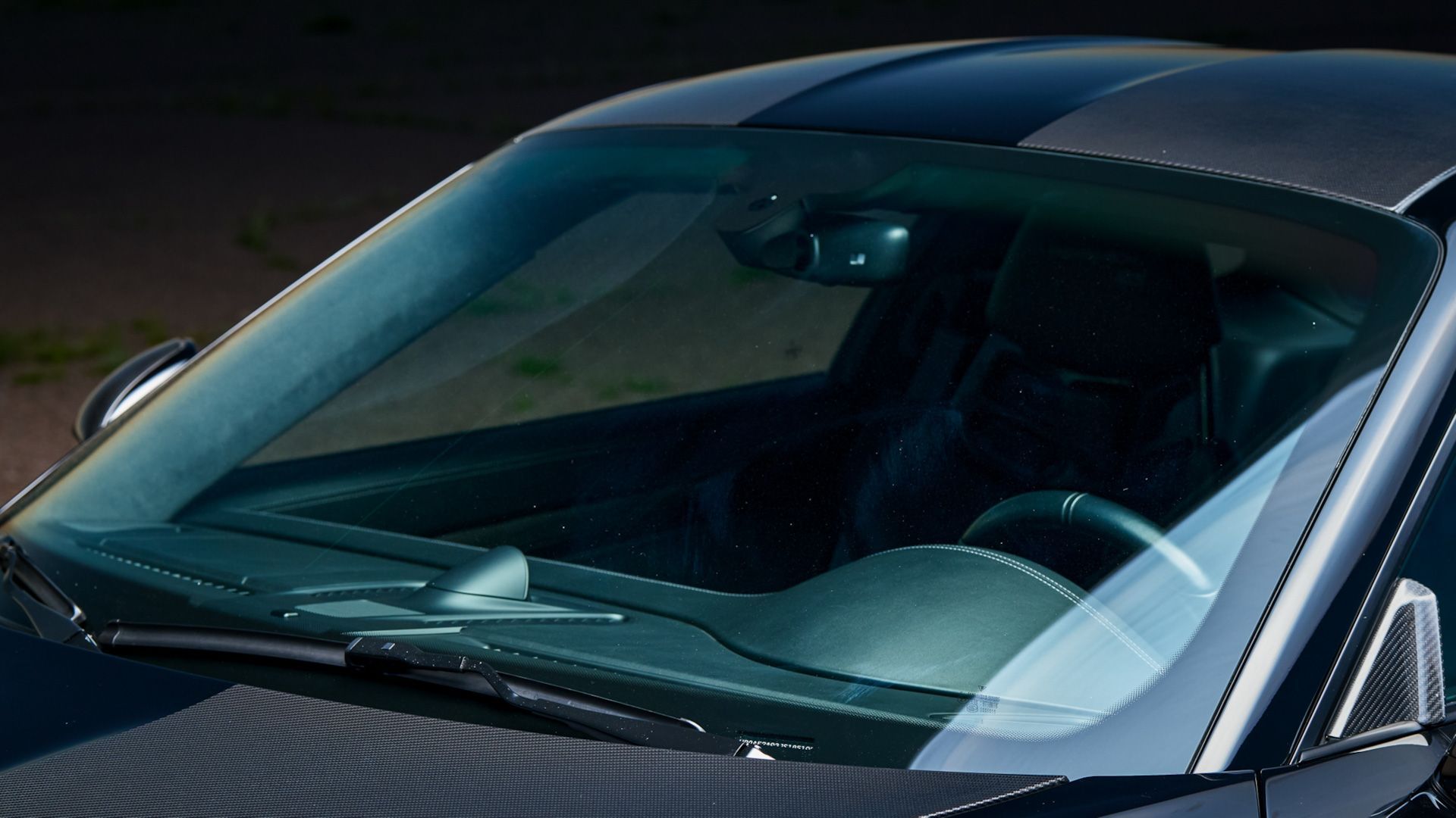 A close up of the windshield of a black car.