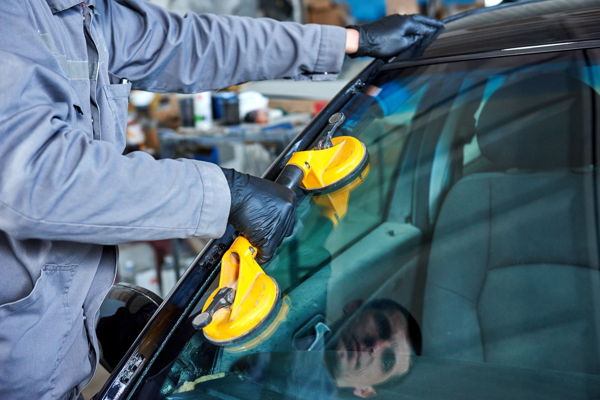 A man is installing a windshield on a car.