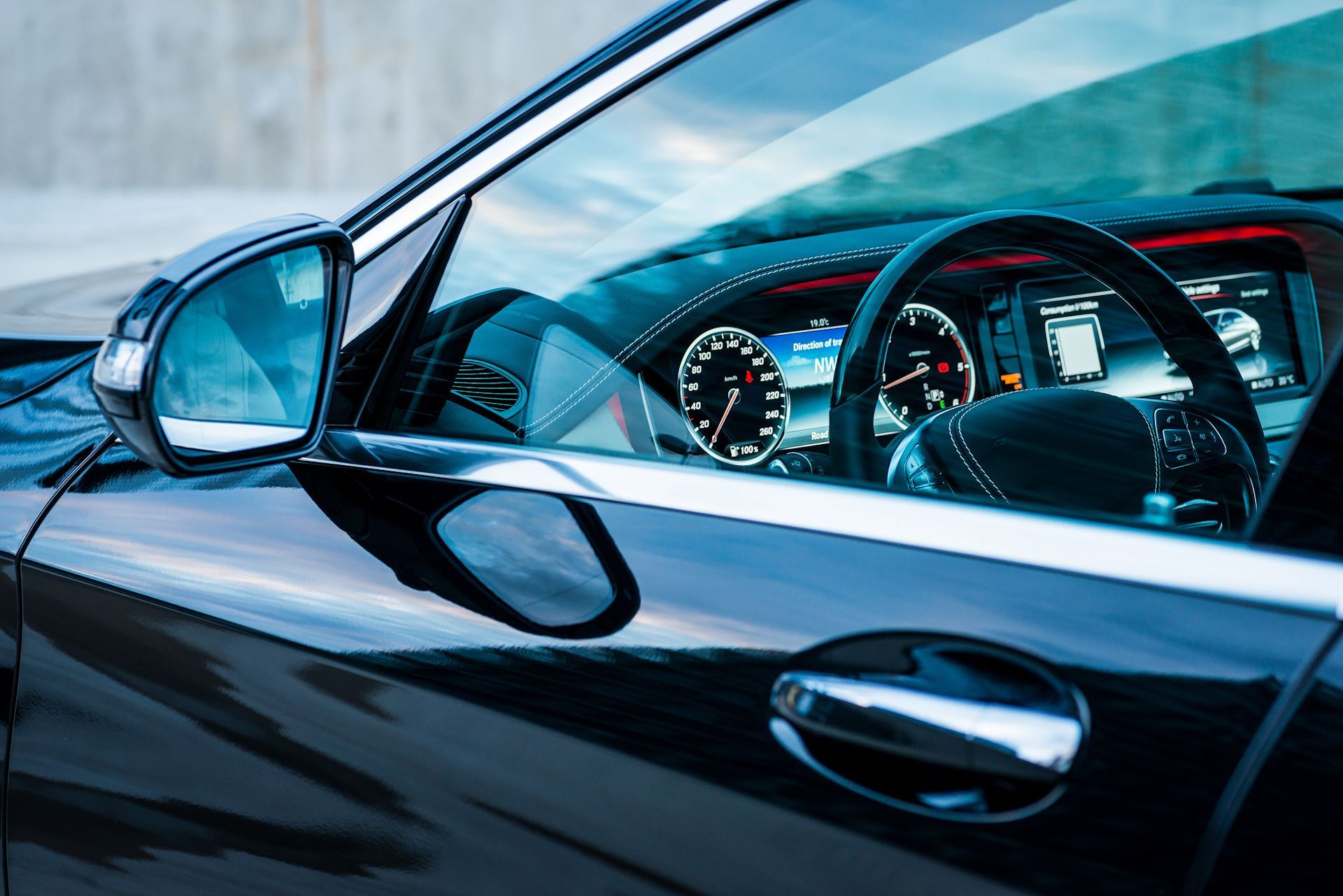 A black car with a steering wheel and a rear view mirror