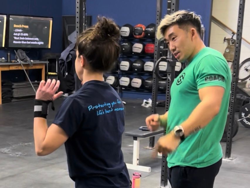 A man in a green shirt is talking to a woman in a blue shirt that says productivity