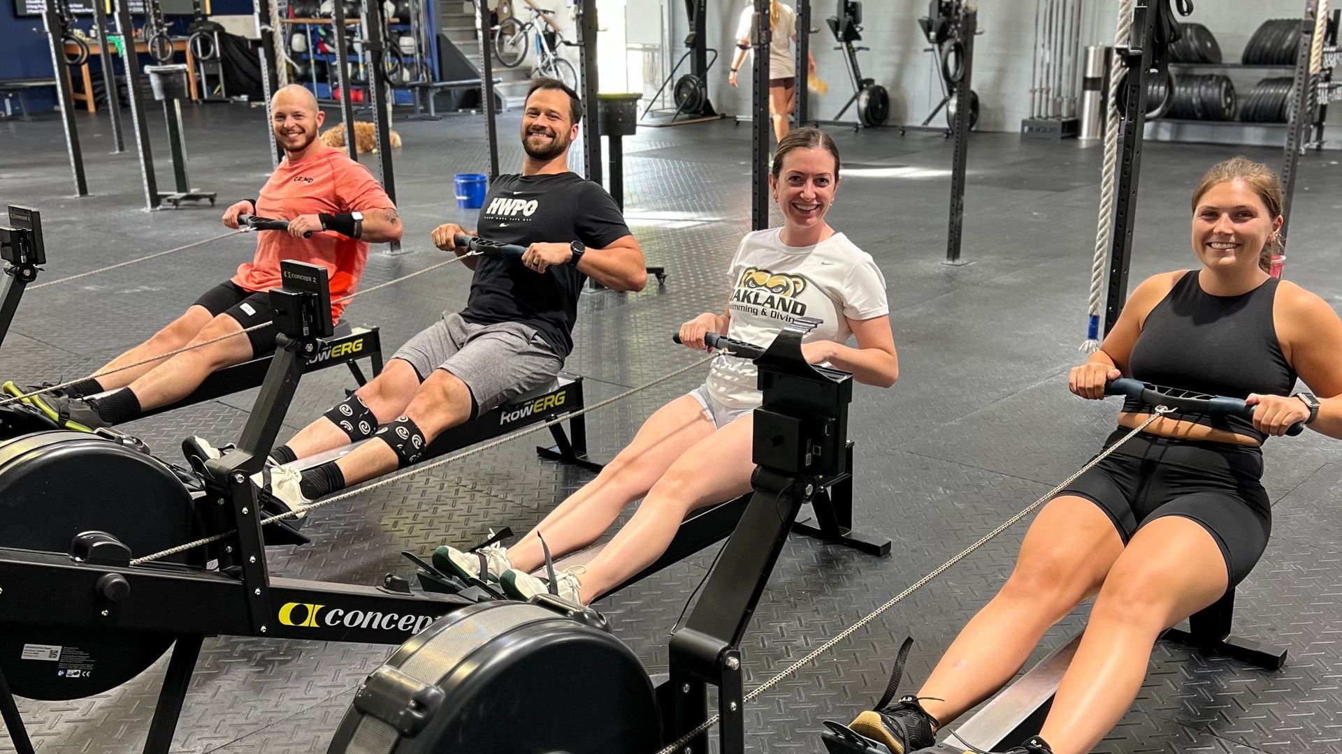 A group of people are rowing rowing machines in a gym.