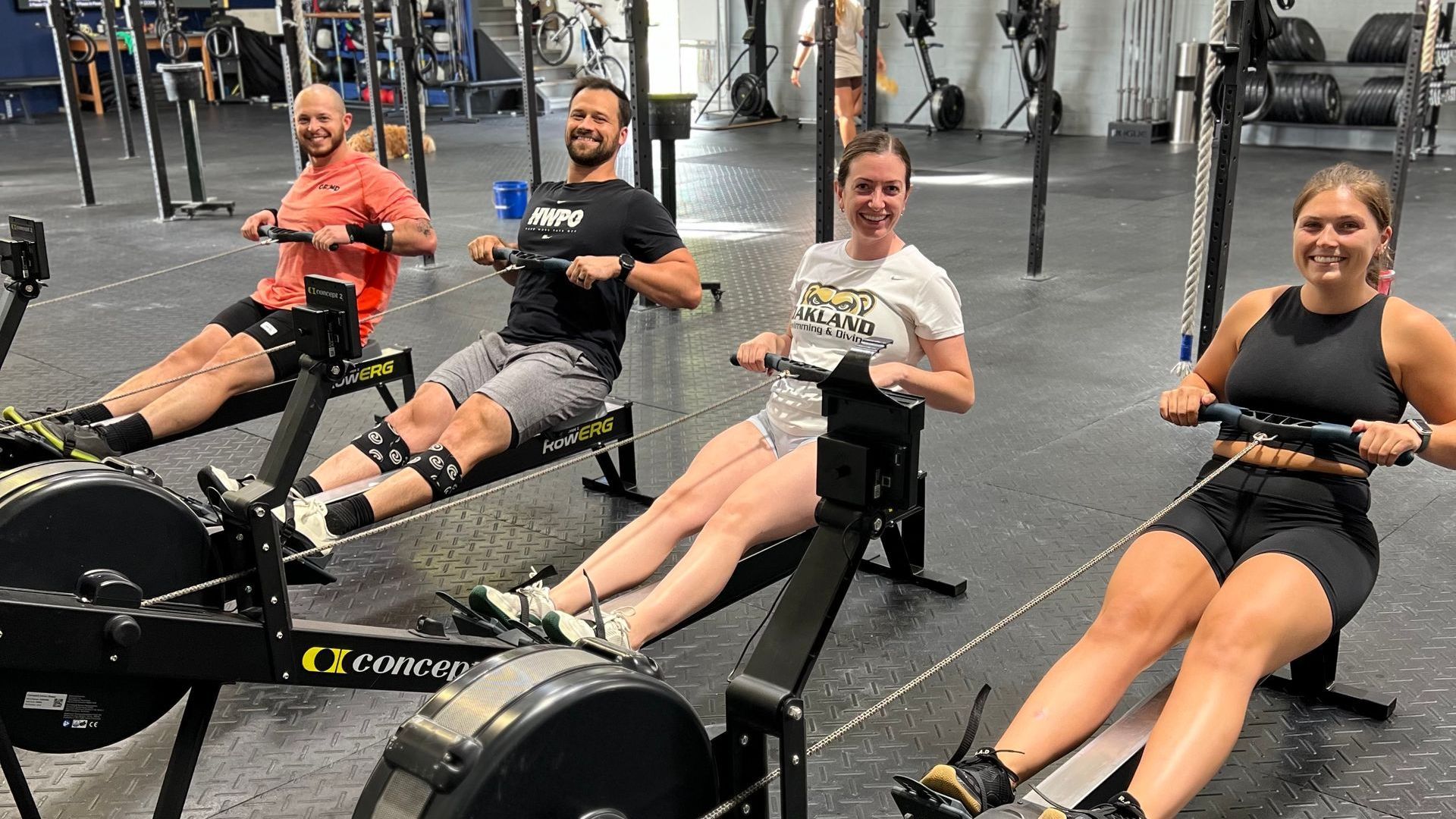 A group of people are rowing rowing machines in a gym.