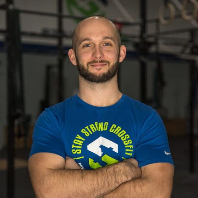 A man wearing a blue shirt that says stay strong crossfit