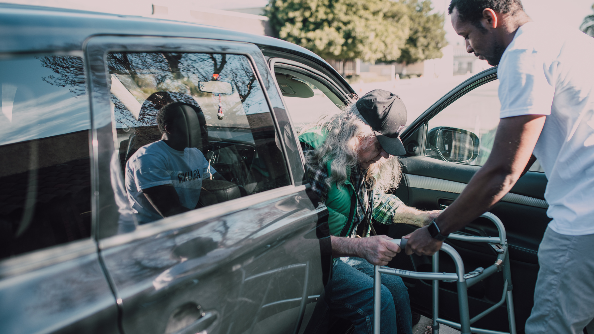 Care home: Elderly people at a table with a nurse, one woman in a wheelchair, a doctor talking to others.
