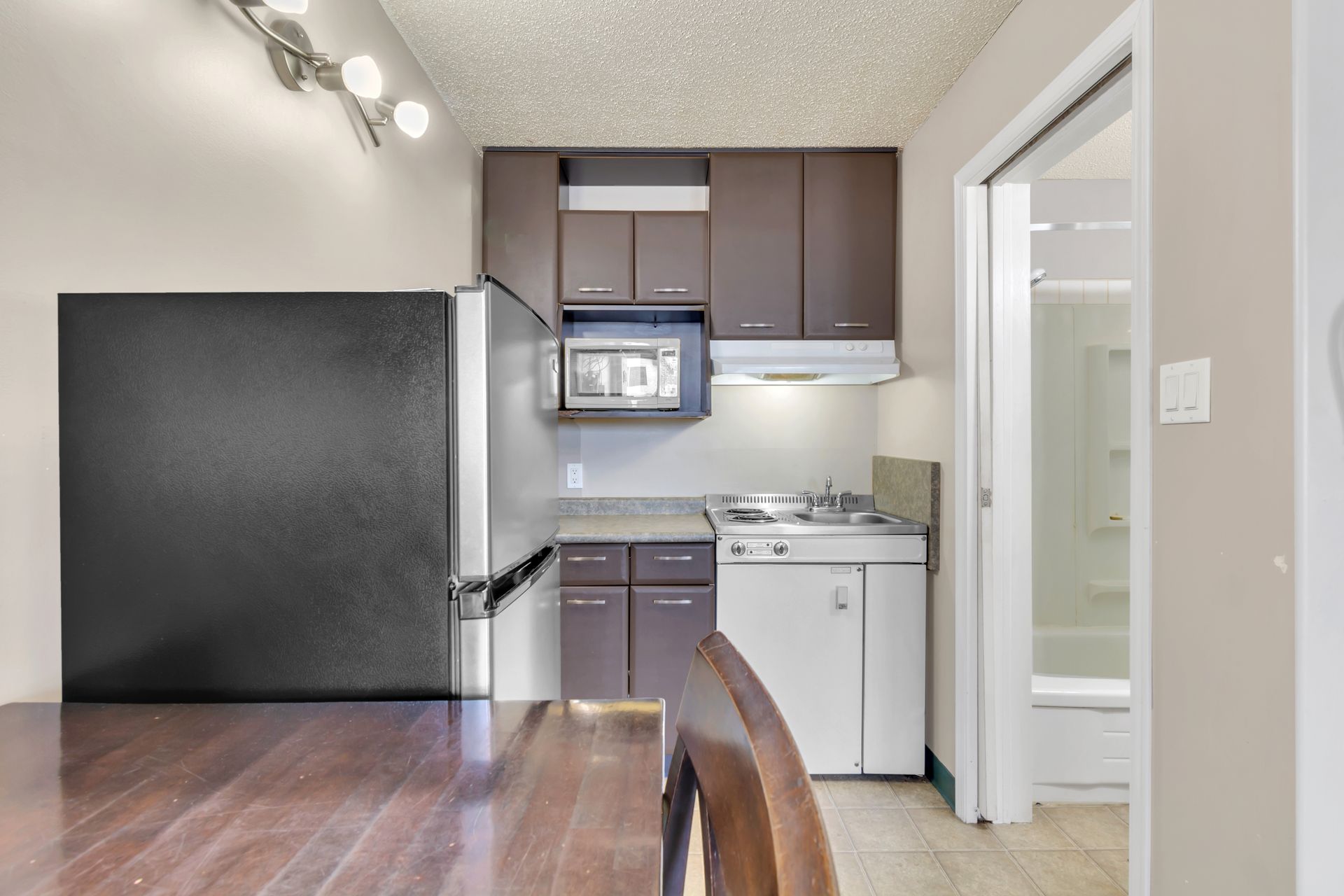 A small kitchen with brown cabinets and white appliances