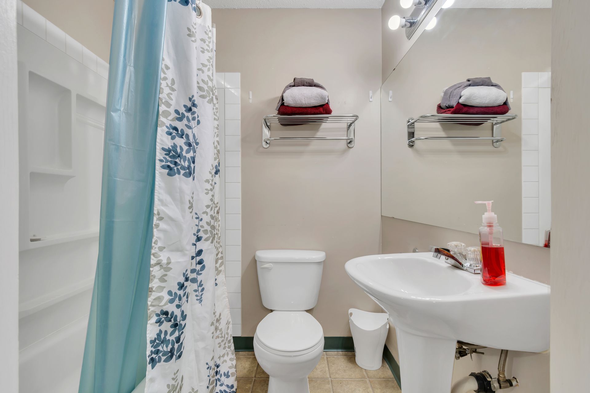 A bathroom with a toilet , sink and shower curtain.