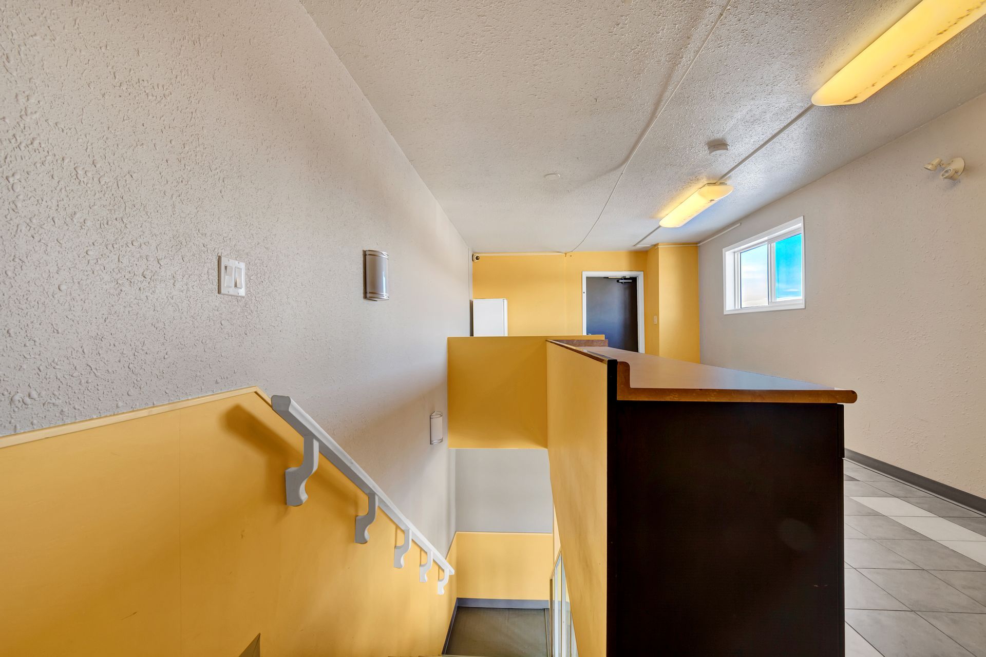 A long hallway with stairs leading up to the second floor of a building.