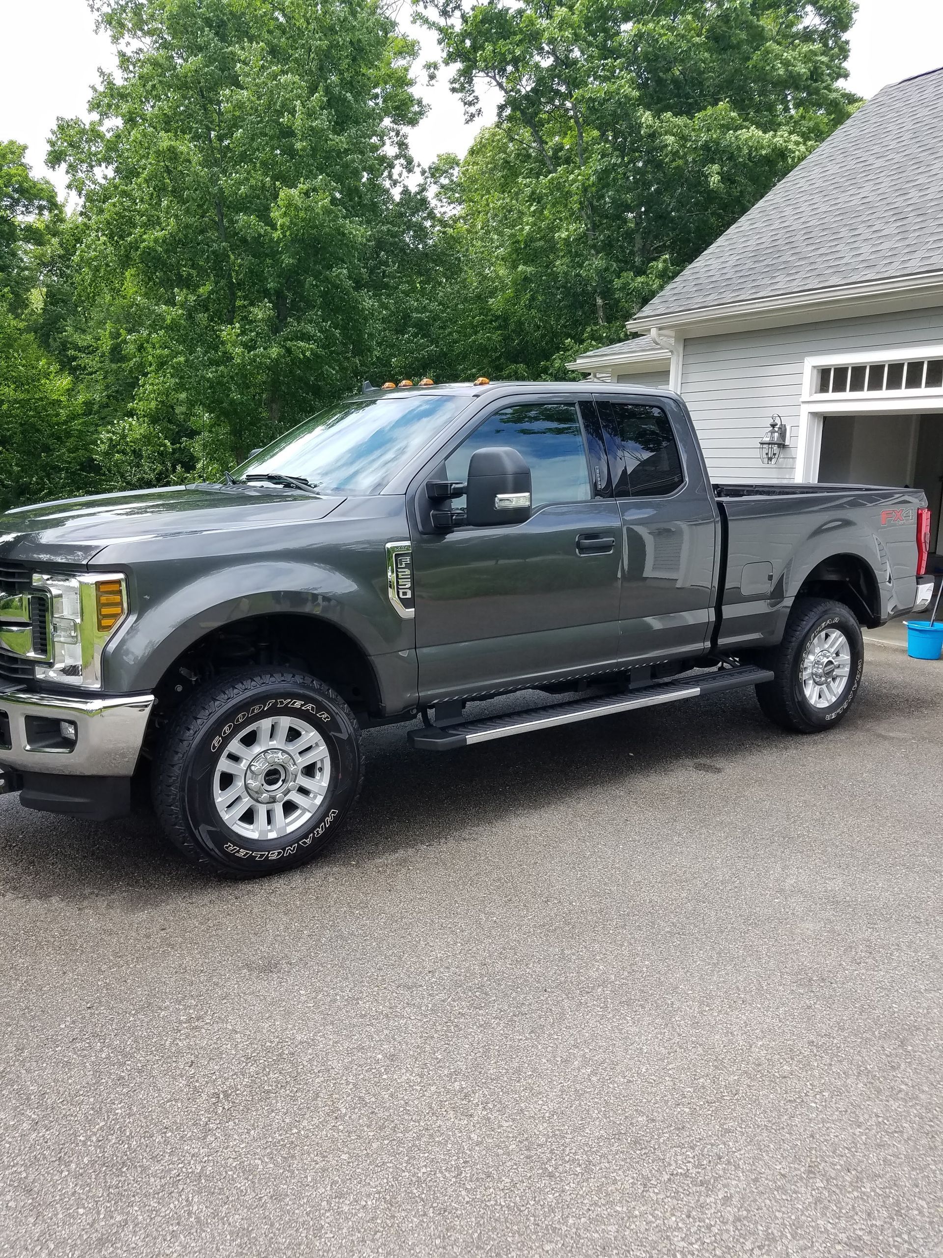 A gray pickup truck is parked in a driveway in front of a house.