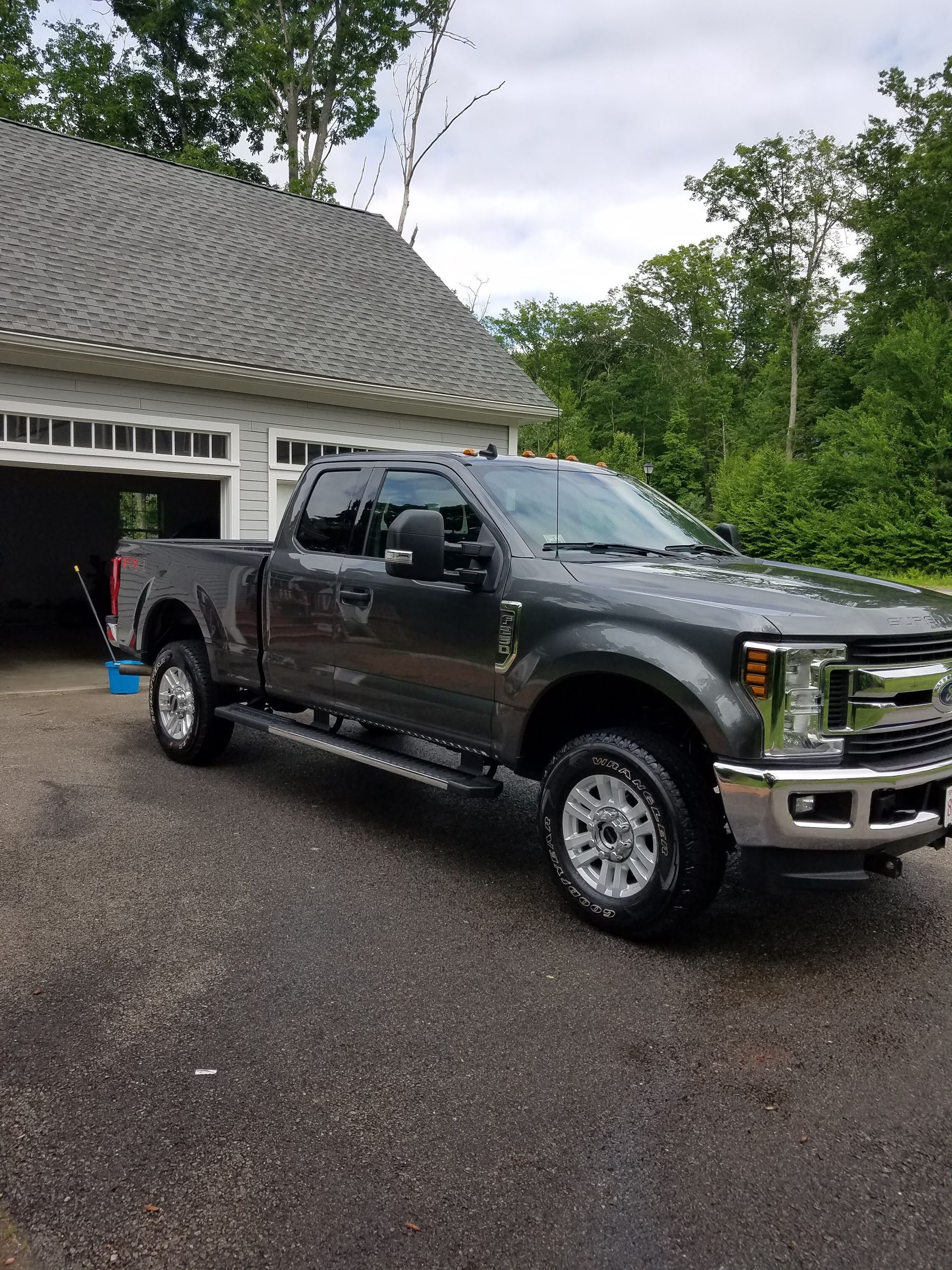A gray pickup truck is parked in front of a garage.
