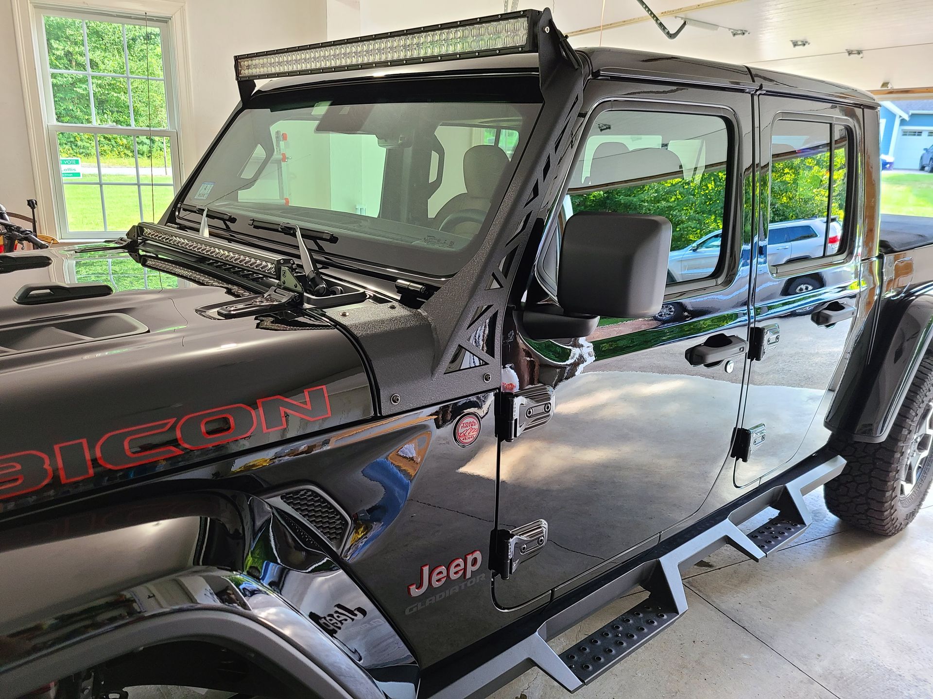 A black jeep wrangler is parked in a garage.