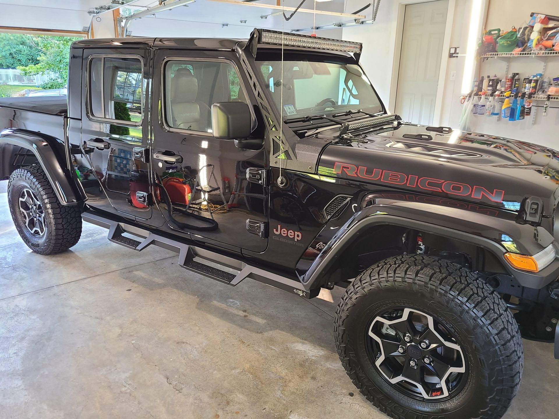 A black jeep wrangler is parked in a garage.