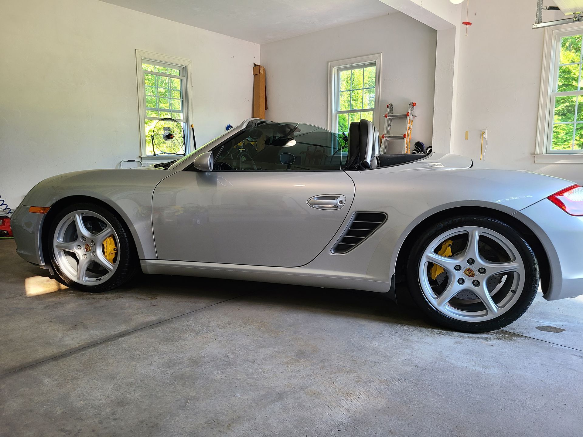 A silver sports car is parked in a garage.