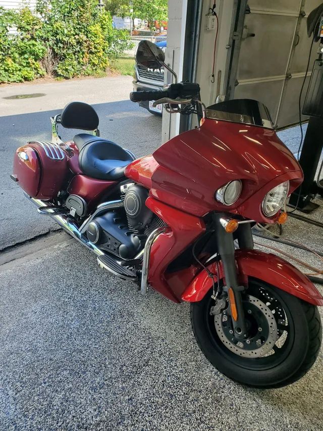 A red motorcycle is parked in a garage.
