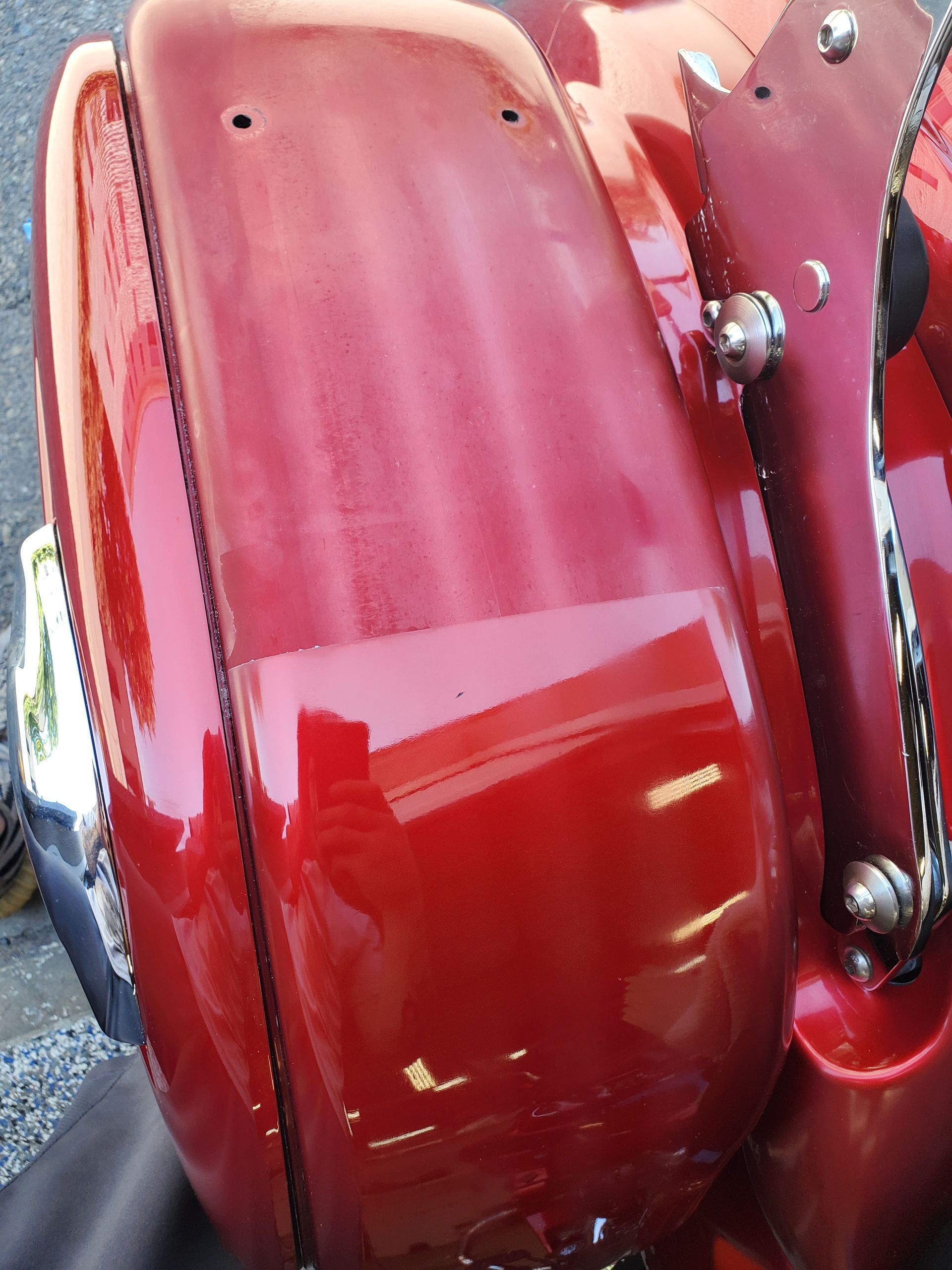 A red motorcycle is parked on the side of the road