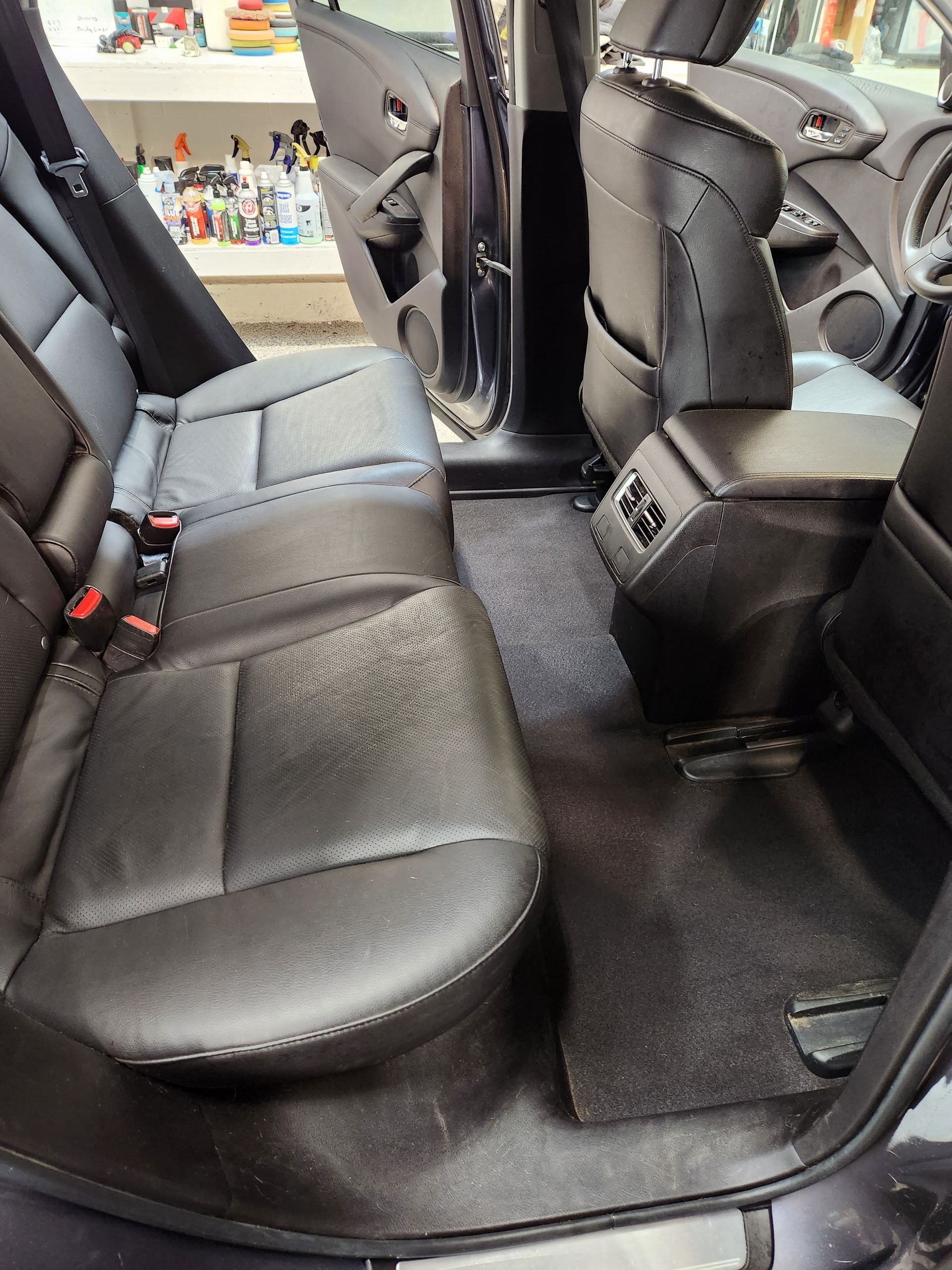 The back seat of a car with black leather seats