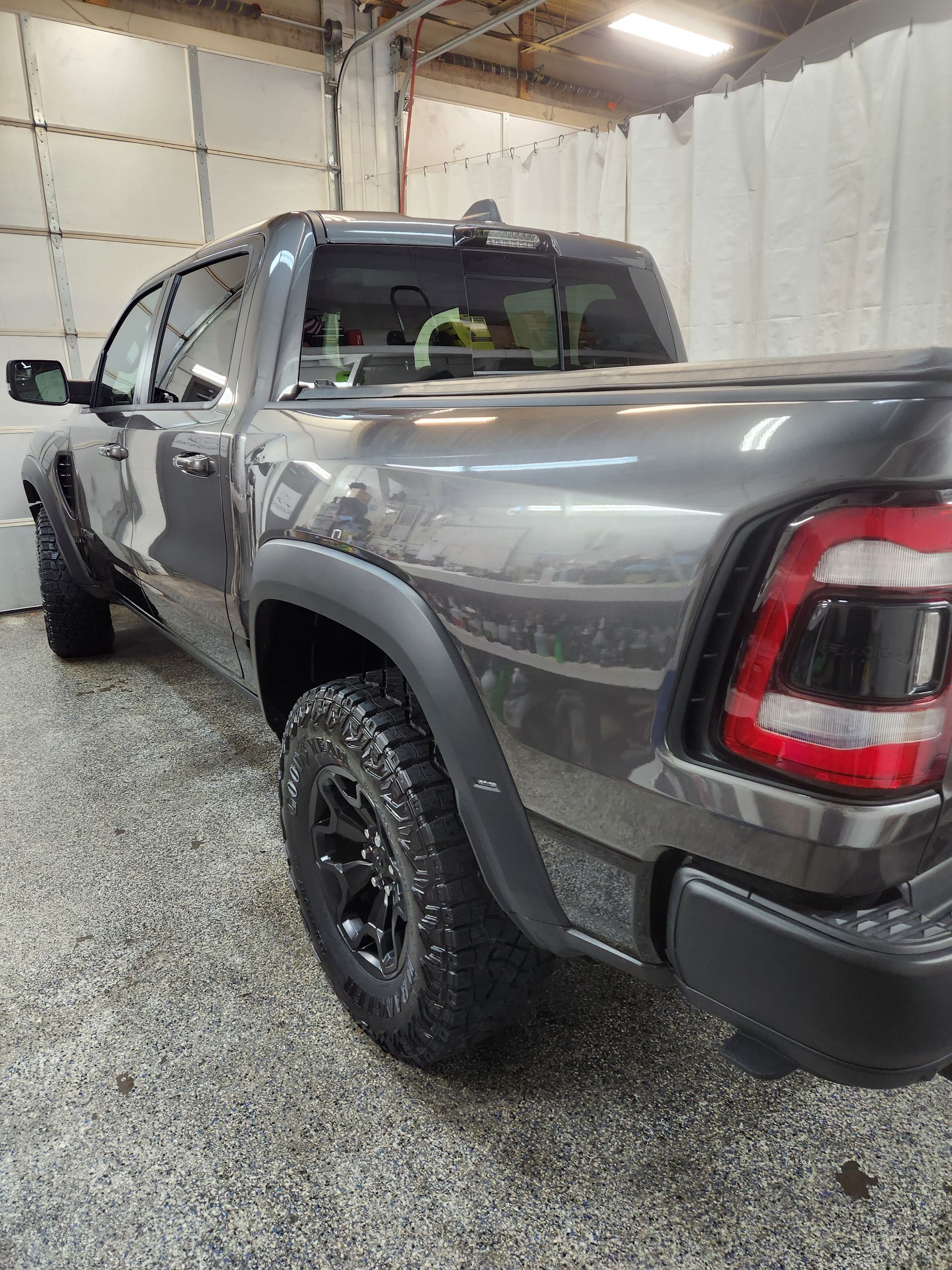 A gray ram truck is parked in a garage.