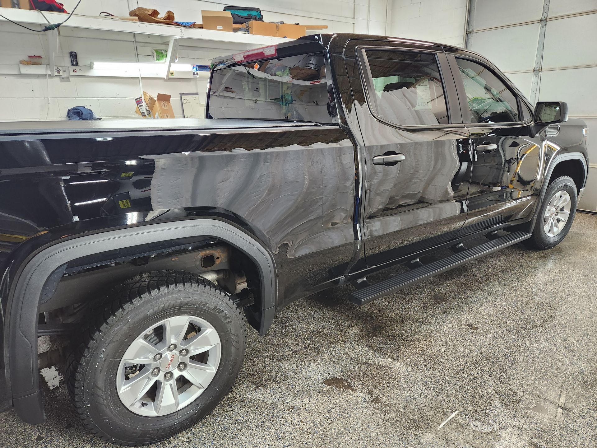A black pickup truck is parked in a garage.