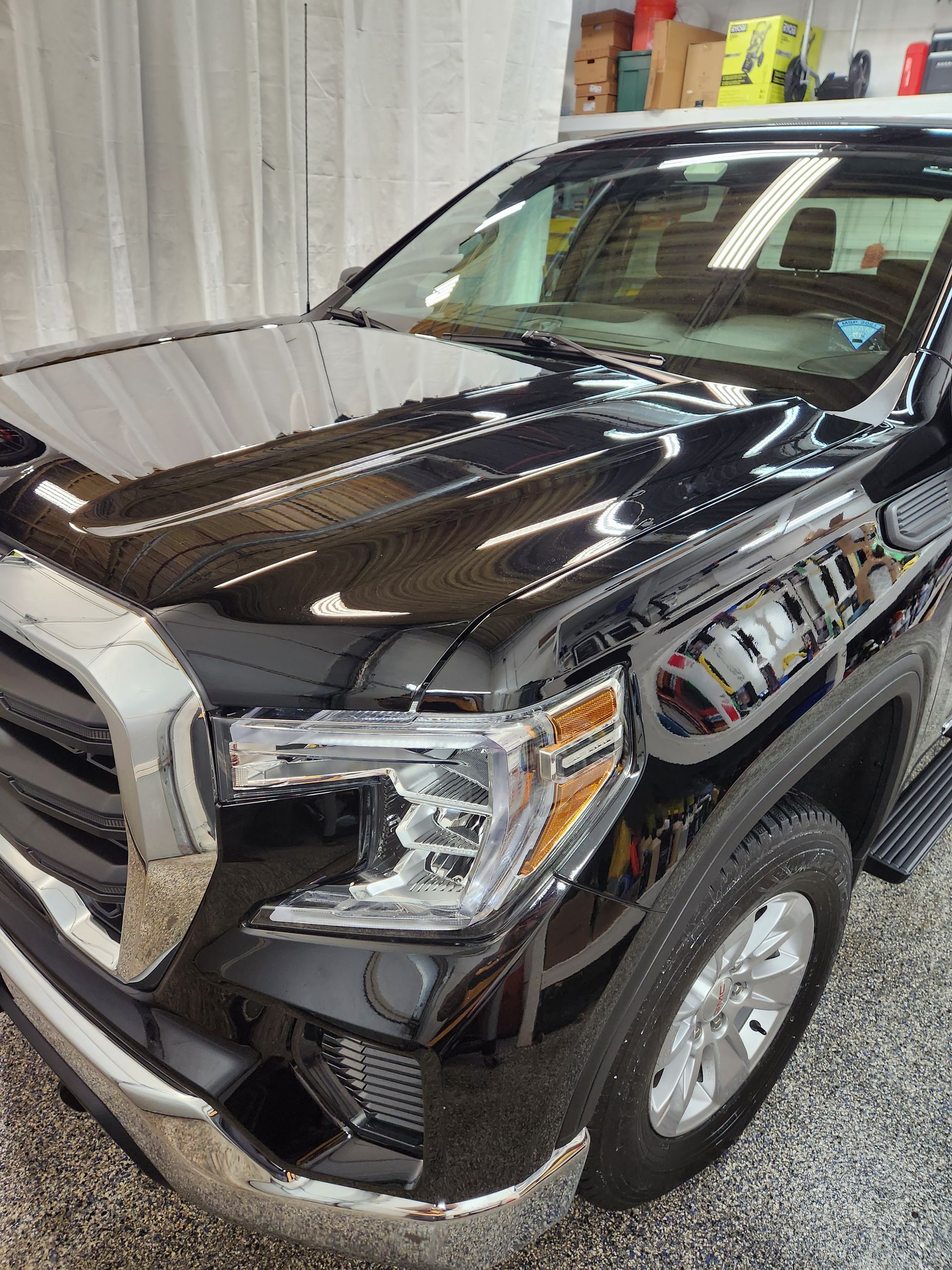 A black pickup truck is parked in a garage.