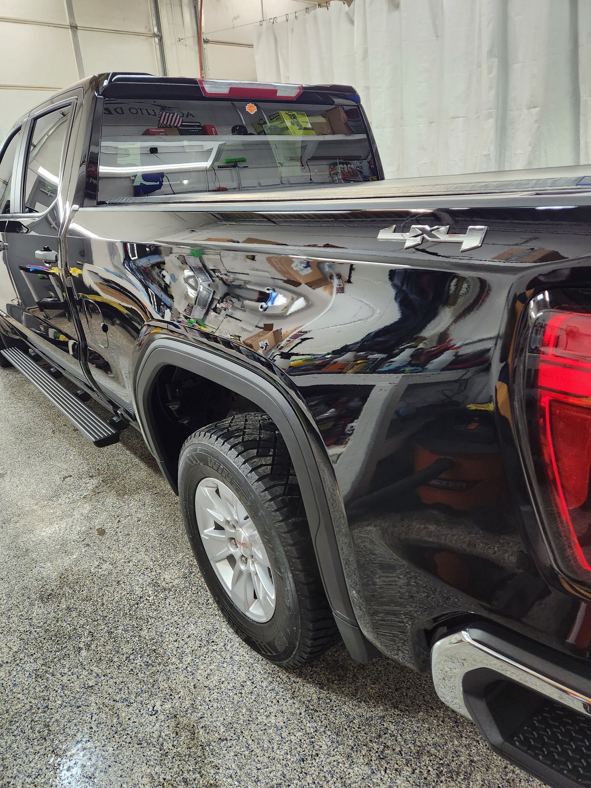 A black pickup truck is parked in a garage.