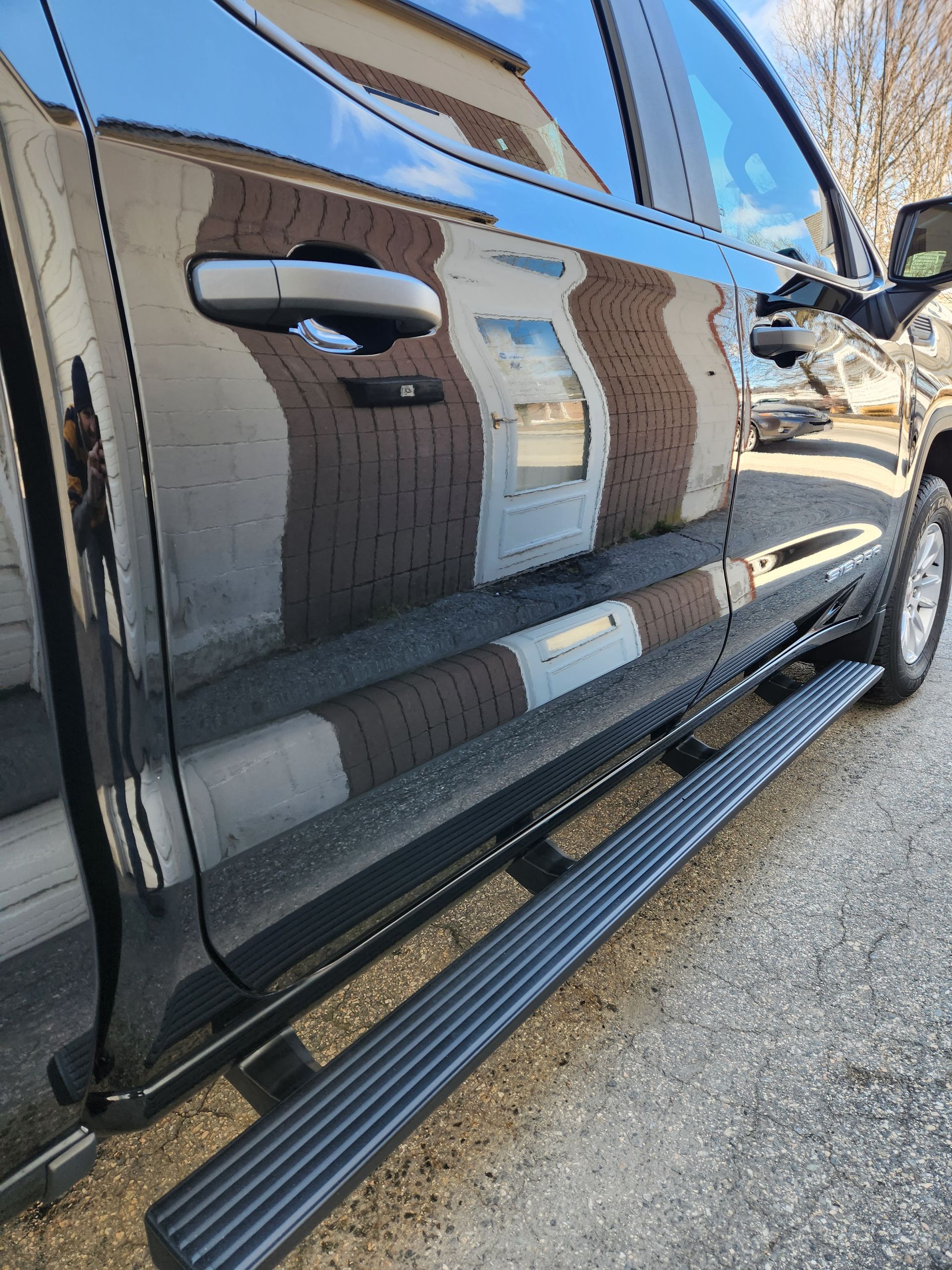 A black truck is parked on the side of the road.