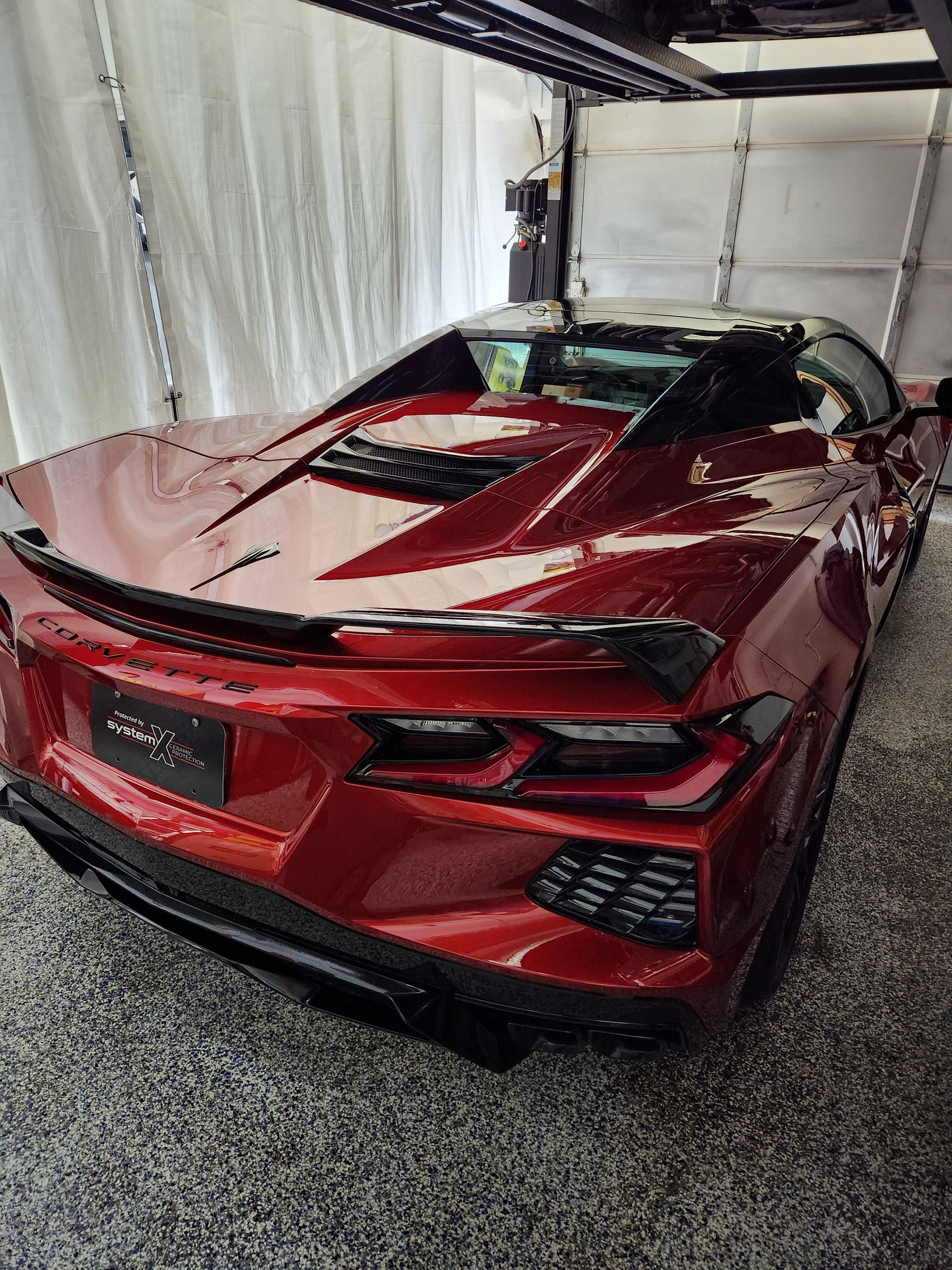 A red sports car is parked in a garage.