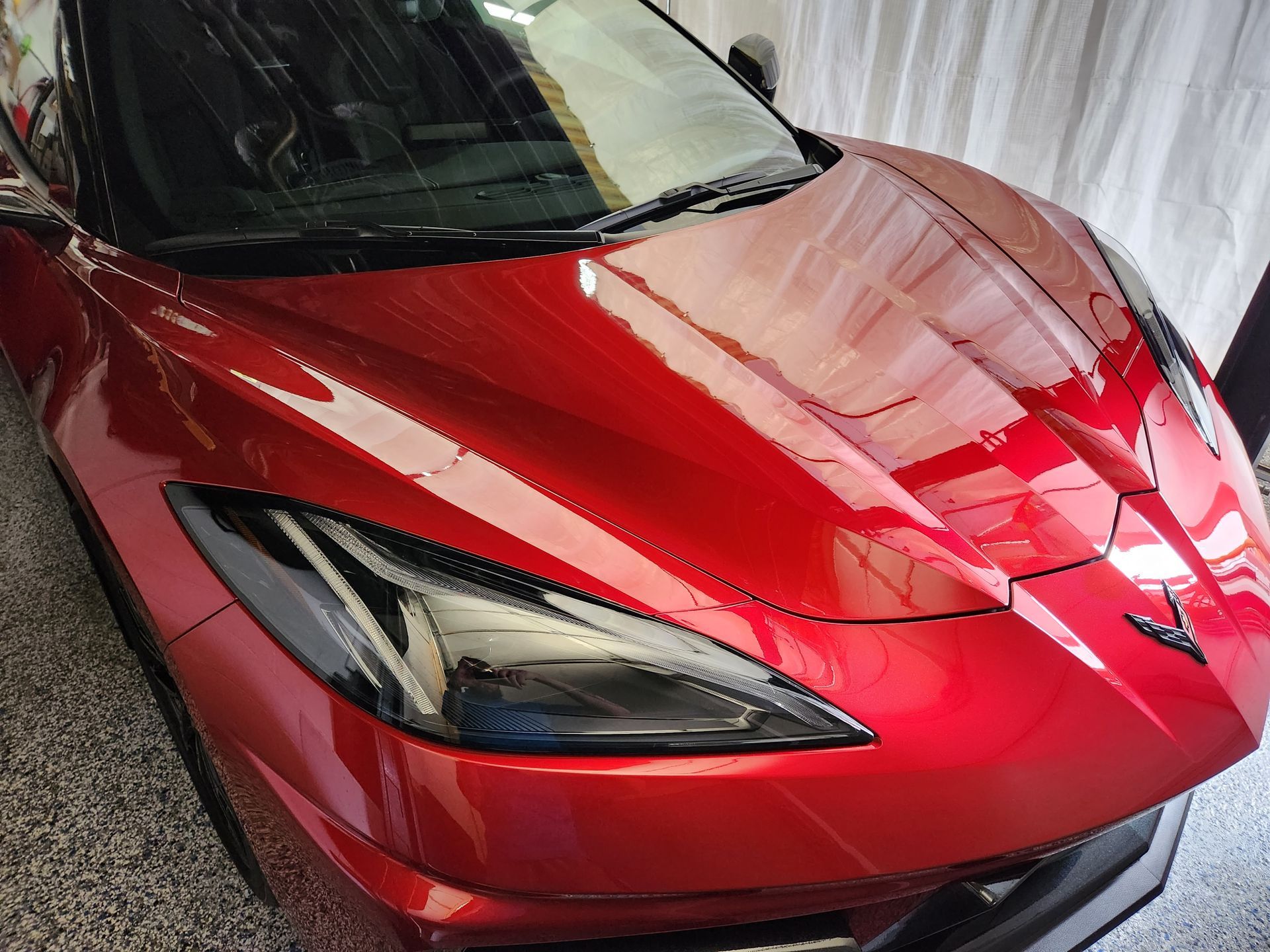 A red sports car is parked in a garage.