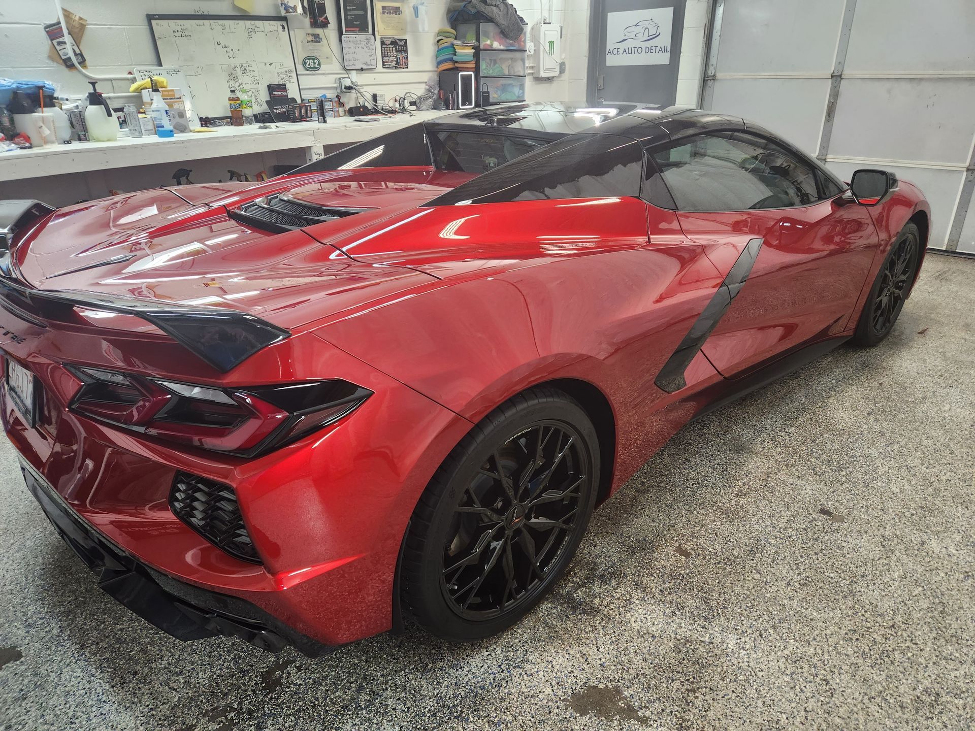 A red sports car is parked in a garage.