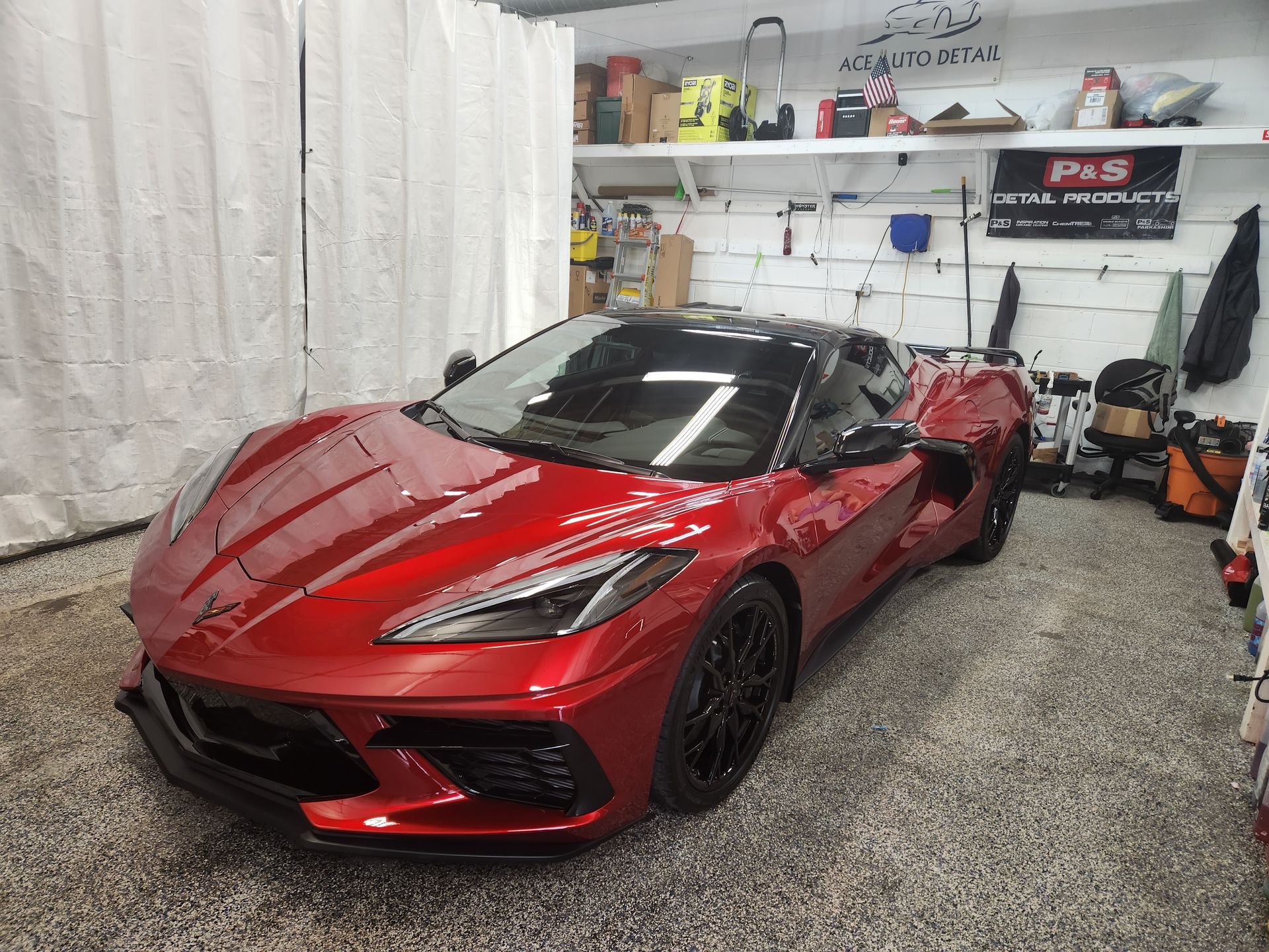 A red sports car is parked in a garage.